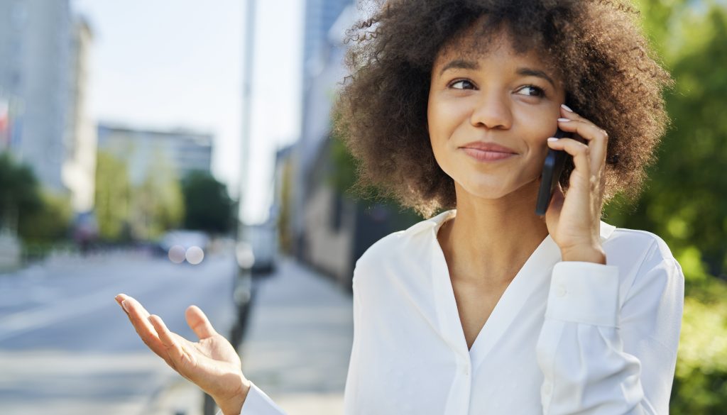 Zakelijke vrouw belt met AI-telefonist – illustratie bij blog over Wat is IVR en AI-telefonie