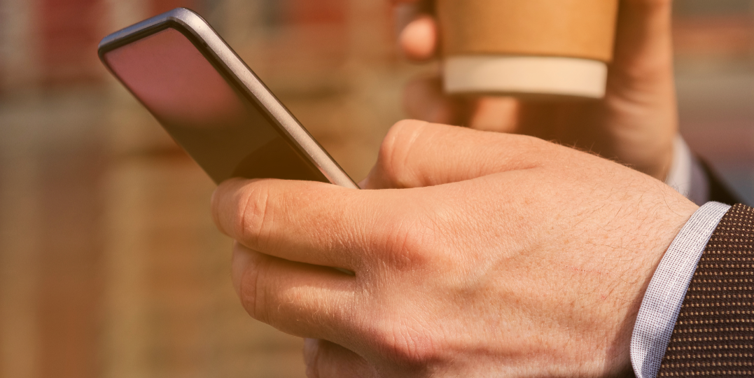 closeup telefoon en koffie in hand